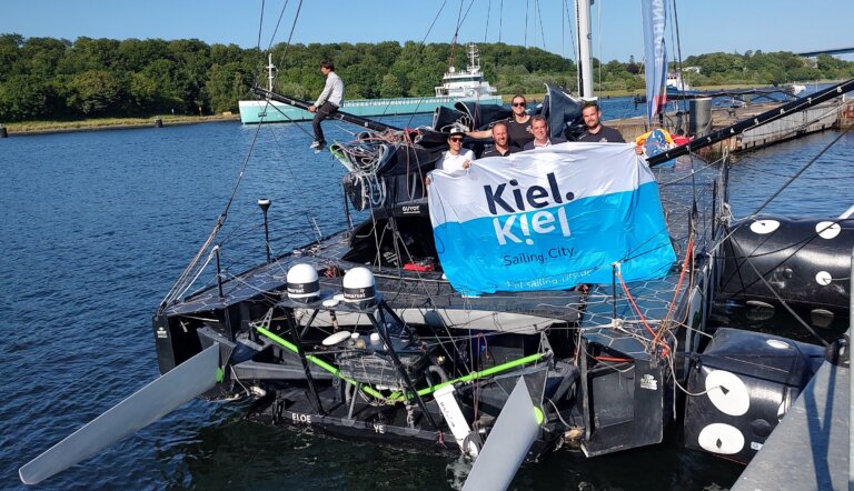 Kiels OB Ulf Kämpfer wird zum Abschied der Yacht von der Crew in die Mitte genommen.