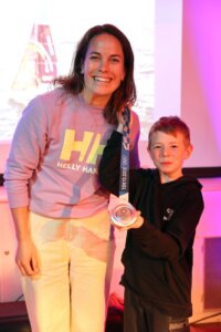 Susann Beucke zeigt mit einem Schüler ihre Silbermedaille.
