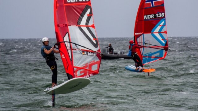 Zwei Surfer rauschen über das Wasser.